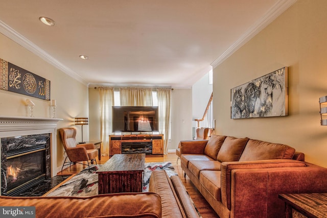 living room featuring crown molding, hardwood / wood-style floors, and a fireplace