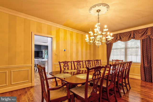 dining space featuring an inviting chandelier, hardwood / wood-style floors, and ornamental molding