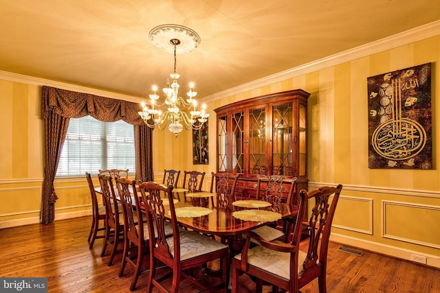 dining area featuring ornamental molding, dark hardwood / wood-style floors, and an inviting chandelier