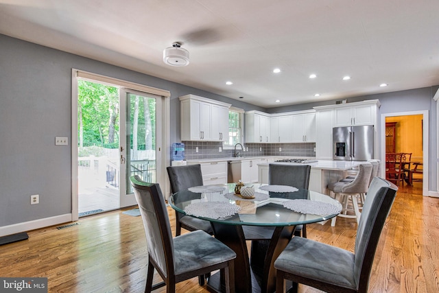 dining space with sink and light hardwood / wood-style flooring