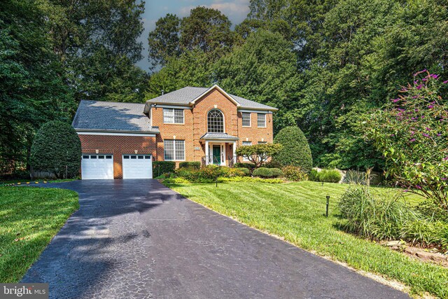 colonial-style house with a garage and a front lawn