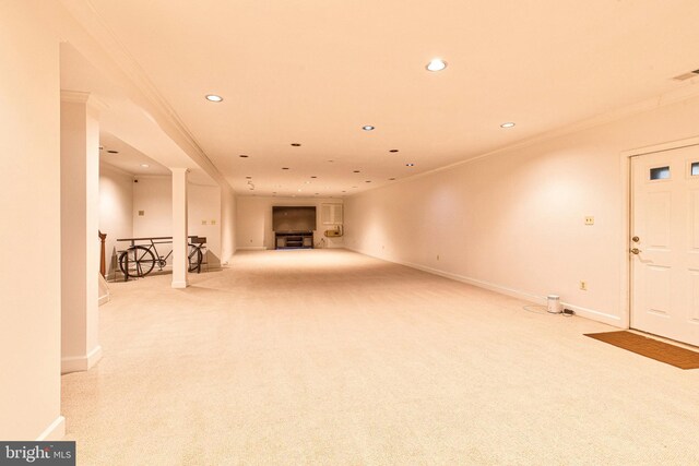 unfurnished living room featuring ornamental molding and light colored carpet