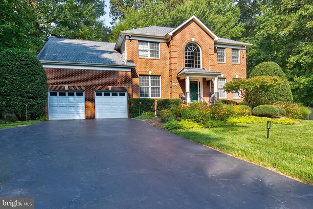 colonial-style house with a garage and a front lawn