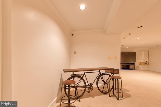 hallway with ornamental molding and carpet