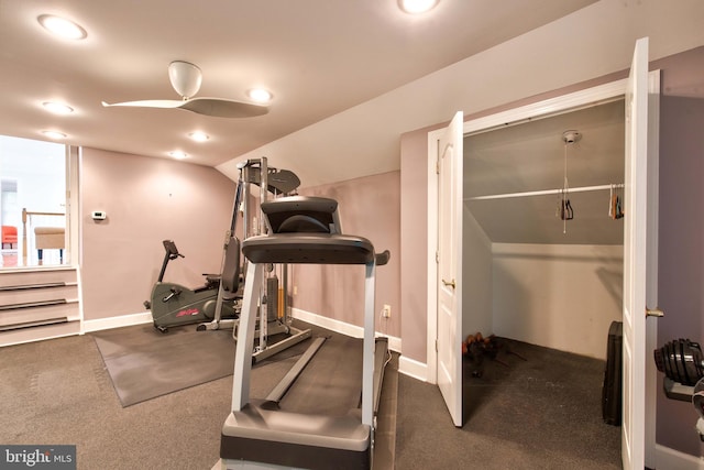 exercise area with ceiling fan, lofted ceiling, and dark colored carpet