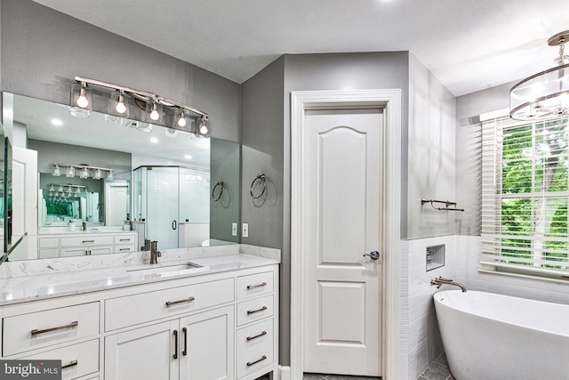 bathroom featuring a chandelier, a healthy amount of sunlight, separate shower and tub, and vanity