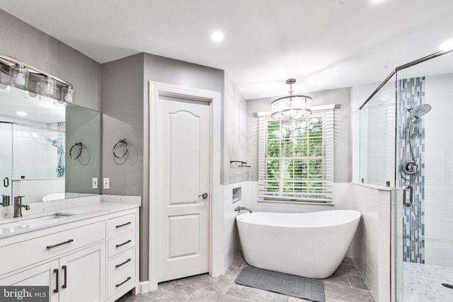 bathroom with plus walk in shower, tile walls, vanity, and an inviting chandelier