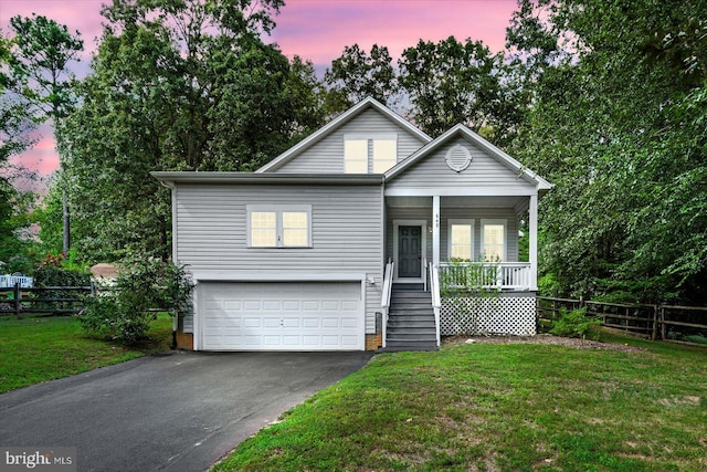 view of front of house with a yard, a porch, and a garage