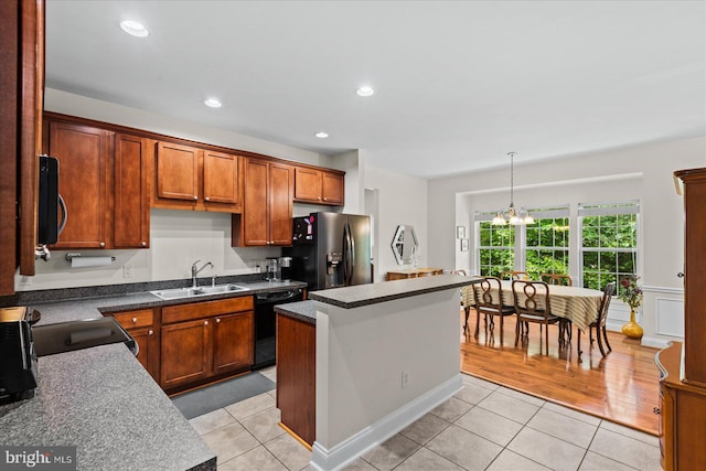 kitchen featuring appliances with stainless steel finishes, hanging light fixtures, light tile patterned floors, a center island, and sink