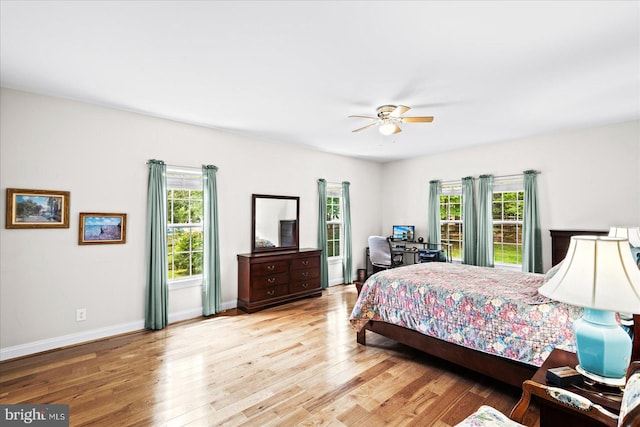 bedroom with light hardwood / wood-style flooring, multiple windows, and ceiling fan