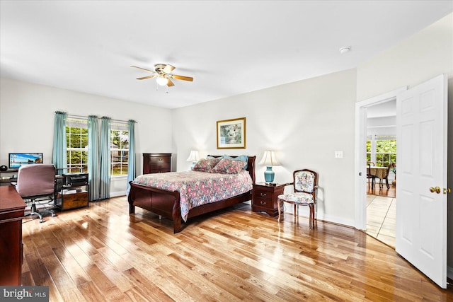 bedroom featuring ceiling fan, hardwood / wood-style floors, and multiple windows