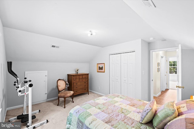 bedroom featuring light carpet, lofted ceiling, and a closet