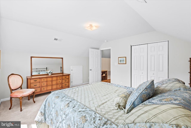 bedroom featuring lofted ceiling, a closet, and light colored carpet