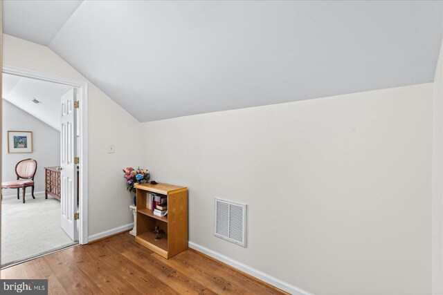 bonus room with lofted ceiling and hardwood / wood-style floors