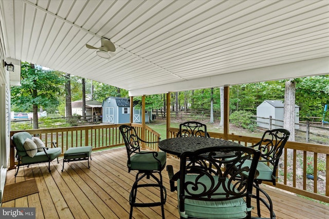 wooden deck with ceiling fan and a storage shed