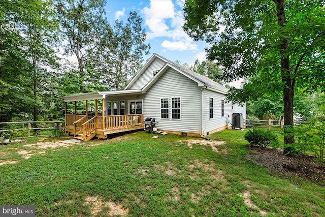 back of house with cooling unit, a deck, and a yard