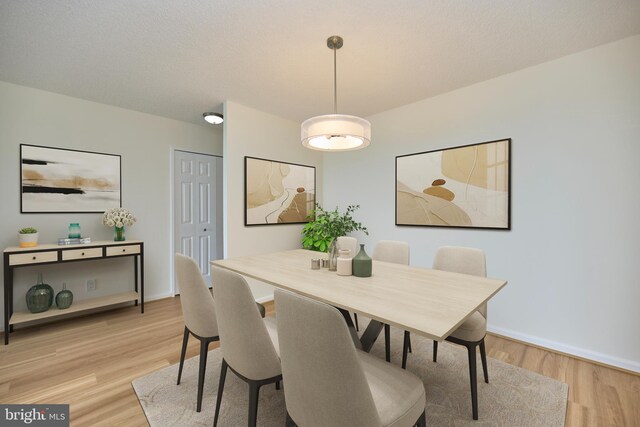 dining room featuring light wood-style floors and baseboards