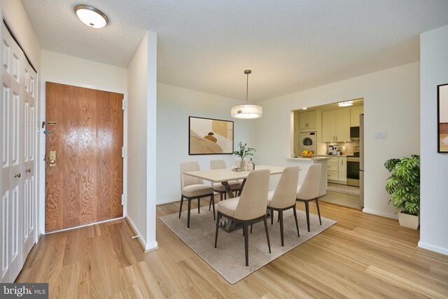 dining area with light wood-type flooring and baseboards