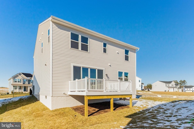 rear view of house featuring a deck and a lawn