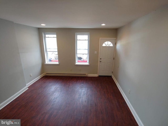 foyer featuring hardwood / wood-style floors, a baseboard heating unit, and a wealth of natural light