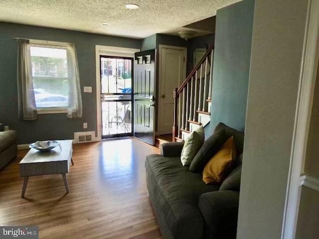 living room featuring a textured ceiling and light wood-type flooring