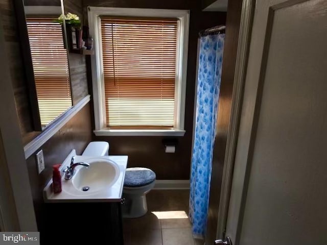 bathroom with toilet, vanity, plenty of natural light, curtained shower, and tile patterned flooring