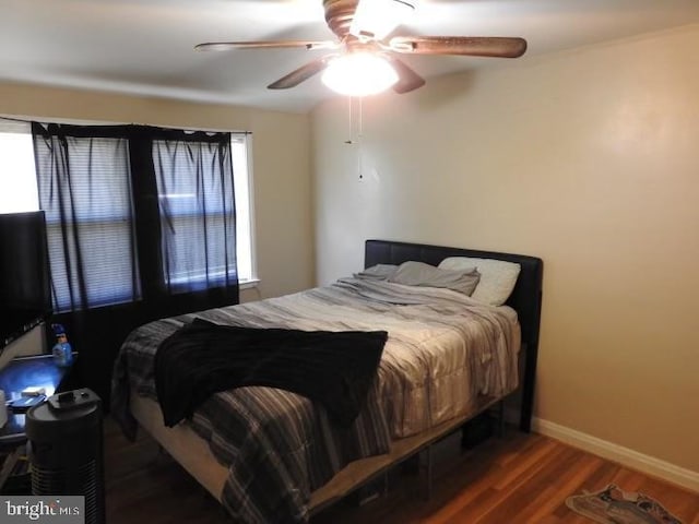 bedroom with ceiling fan and dark hardwood / wood-style flooring