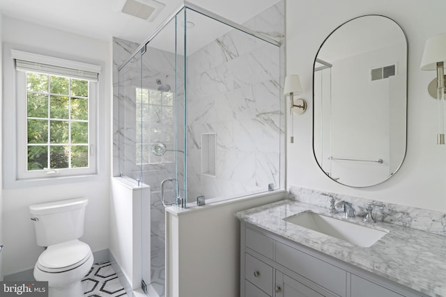 bathroom with tile patterned flooring, toilet, vanity, and walk in shower