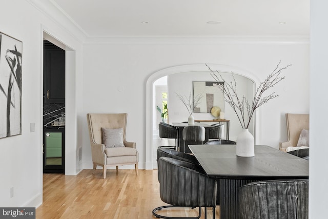 office area with light hardwood / wood-style floors and ornamental molding