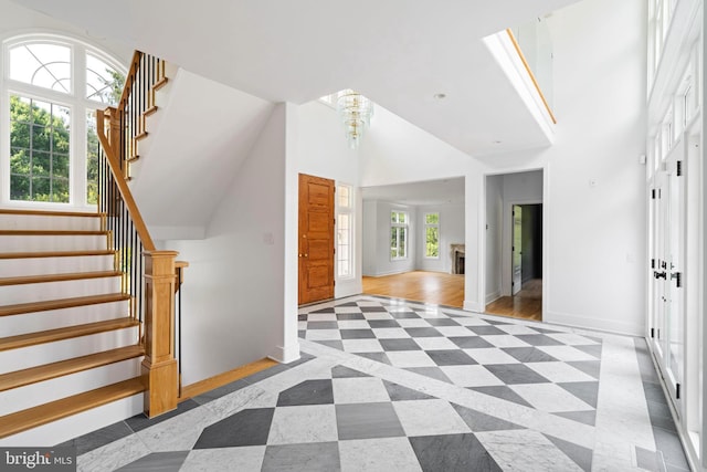 additional living space featuring a wealth of natural light, a high ceiling, and light wood-type flooring