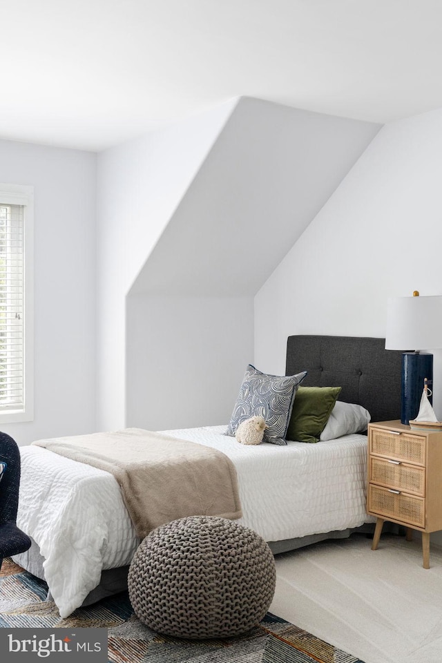 bedroom featuring vaulted ceiling and carpet floors