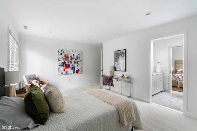 bedroom featuring connected bathroom and light colored carpet