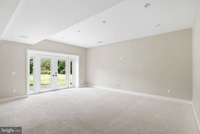 unfurnished room with light carpet and french doors