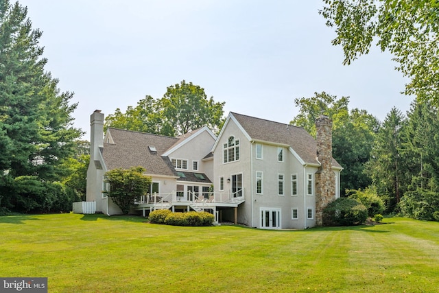 rear view of property featuring a wooden deck and a yard