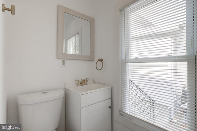 bathroom featuring vanity, toilet, and a healthy amount of sunlight