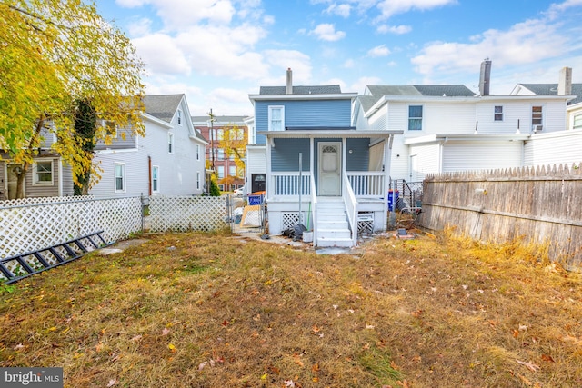 rear view of property with a lawn and covered porch