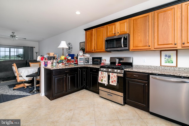 kitchen with light tile patterned floors, stainless steel appliances, and ceiling fan