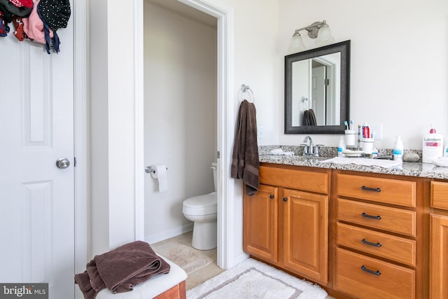 bathroom featuring tile patterned floors, vanity, and toilet