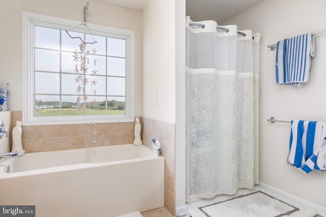 bathroom featuring a notable chandelier and a bathing tub