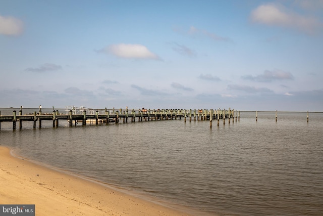 dock area featuring a water view and a beach view