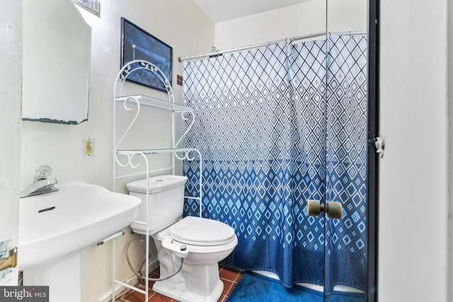 bathroom featuring toilet, tile patterned floors, and sink