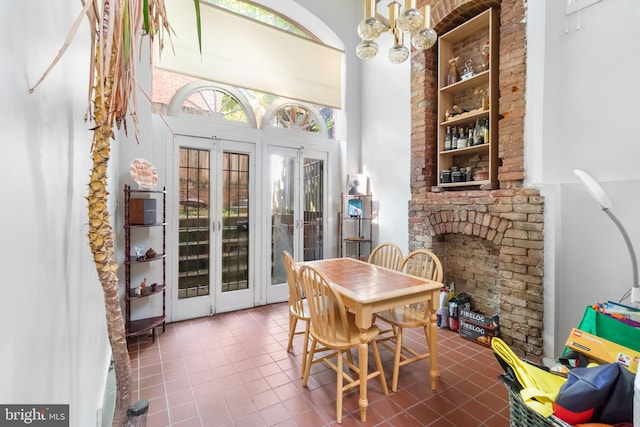 dining room featuring a notable chandelier, a towering ceiling, french doors, and tile patterned floors