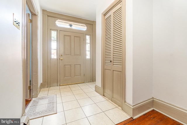 foyer entrance featuring light tile patterned floors and baseboards