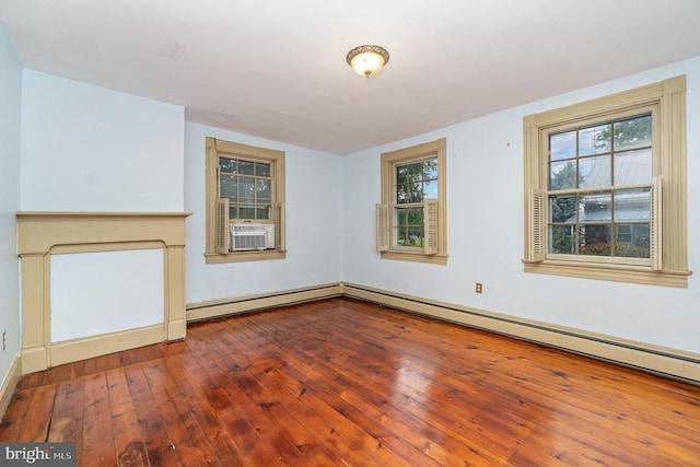 interior space featuring cooling unit, wood-type flooring, a fireplace, and a baseboard heating unit