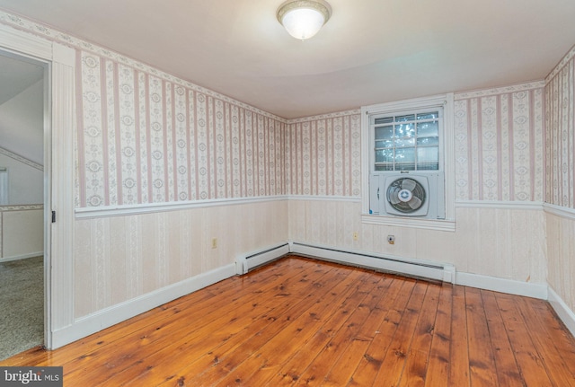 empty room with baseboards, wainscoting, wood finished floors, and wallpapered walls