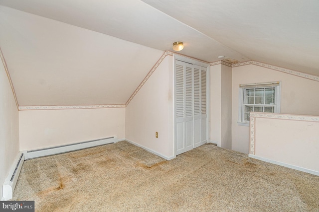 additional living space featuring a baseboard radiator, lofted ceiling, and carpet flooring