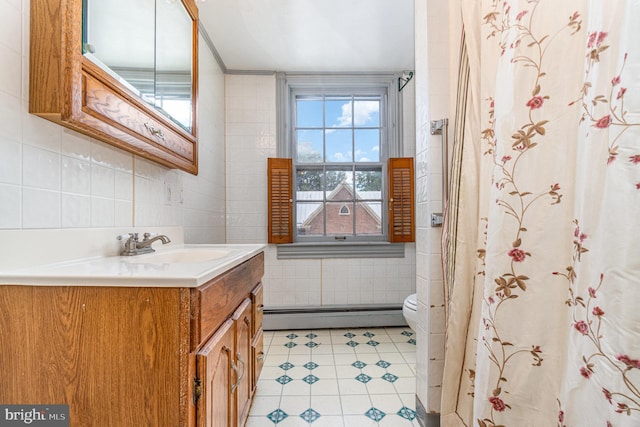 bathroom featuring toilet, tile walls, ornamental molding, vanity, and a baseboard heating unit