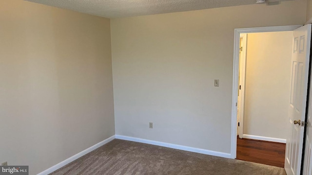 carpeted empty room with a textured ceiling