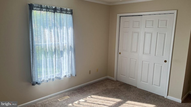 unfurnished bedroom featuring carpet, a closet, and ornamental molding