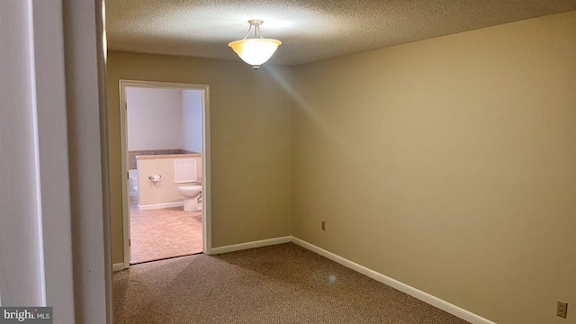 empty room with carpet floors and a textured ceiling